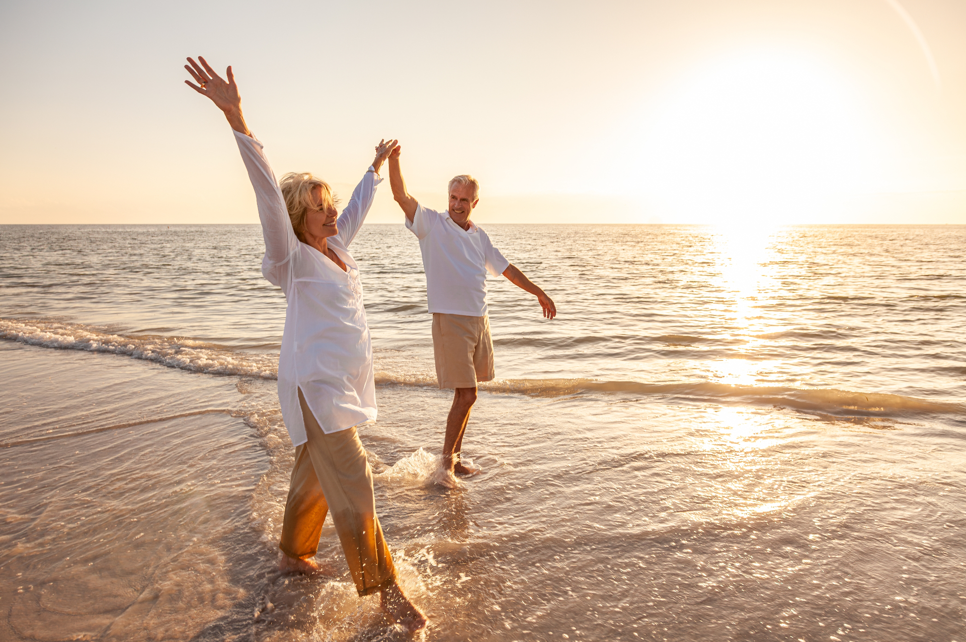 Couple celebrating wellness on a beautiful beach at sunrise